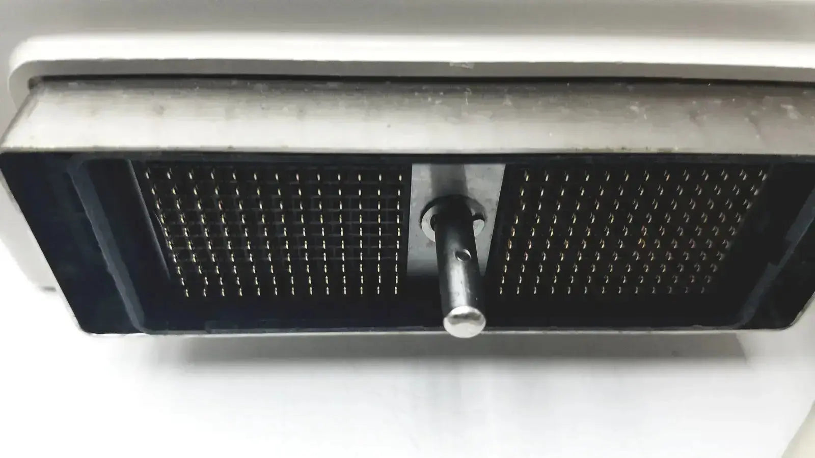 Black rectangular mesh grille with central metallic knob on white surface showing back side of hitachi eup-cc331 biplane transrectal probe