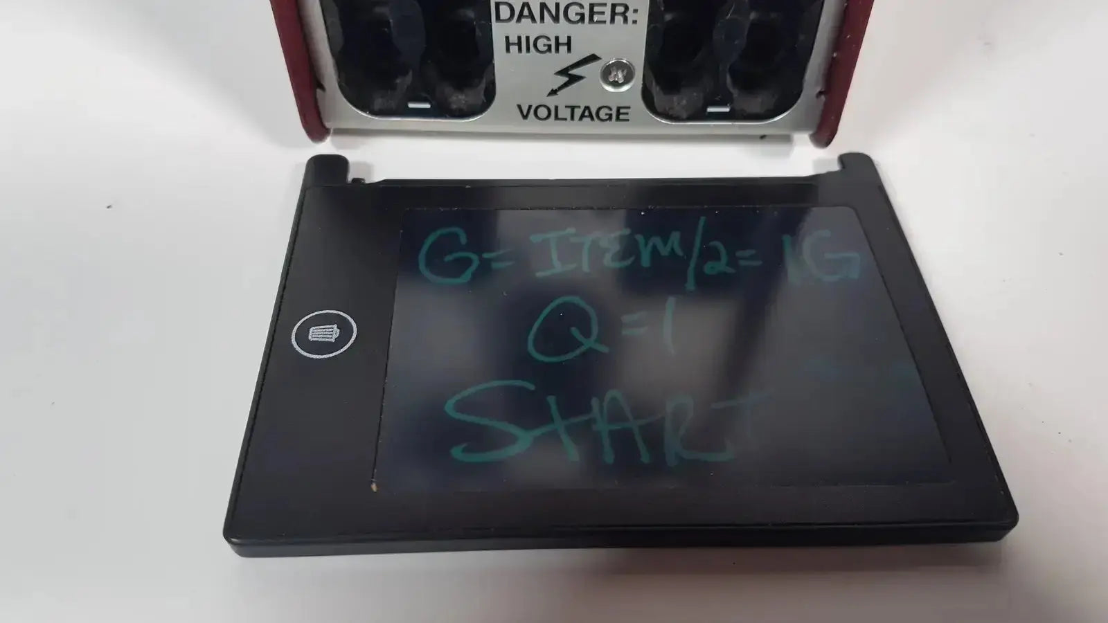 Black rectangular hoefer ps500xt dc power supply with touchscreen displaying handwritten equations and start in green marker