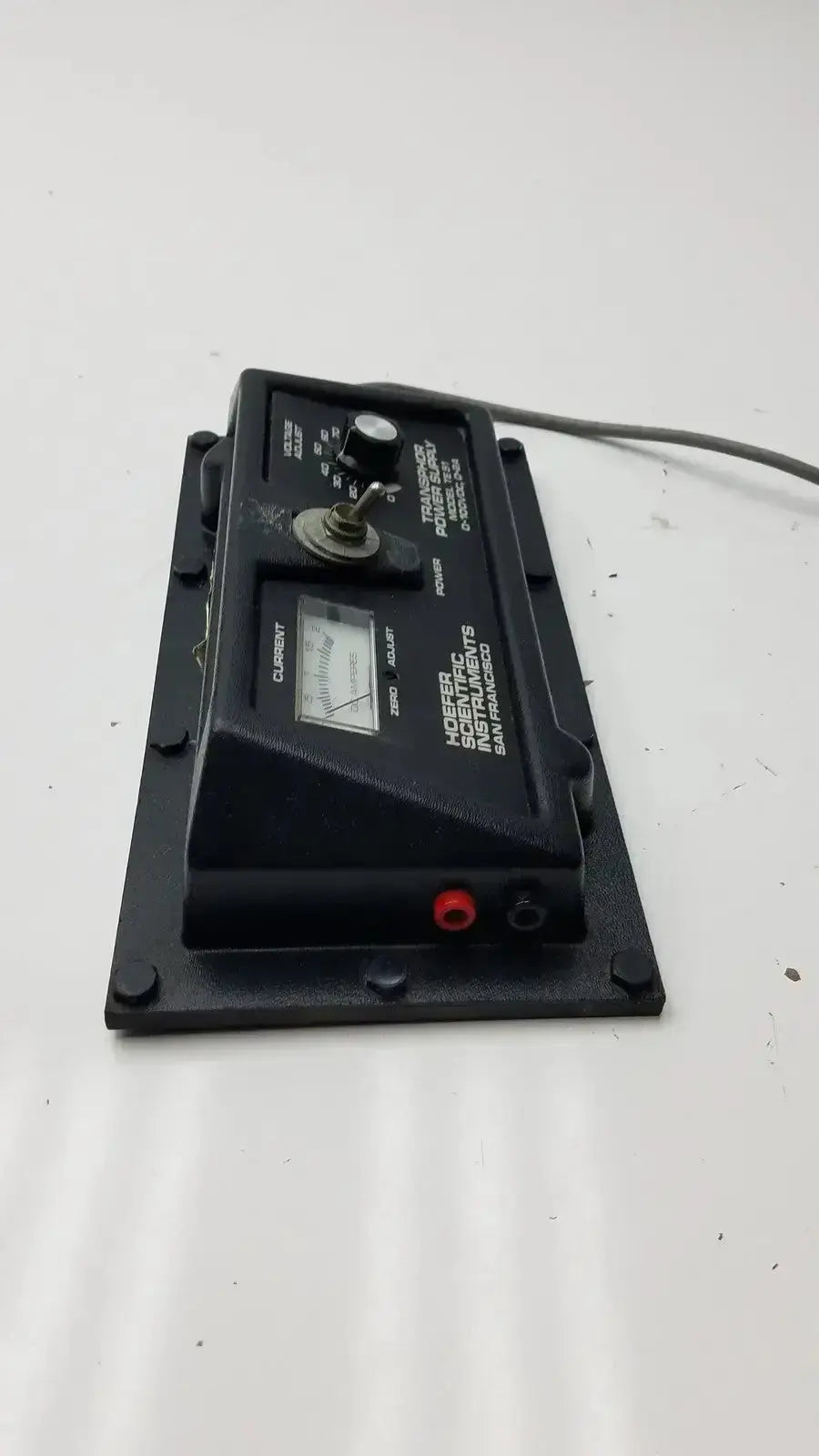 Black plastic analog multimeter with circular dial and red black leads for hoefer scientific transphor power supply use