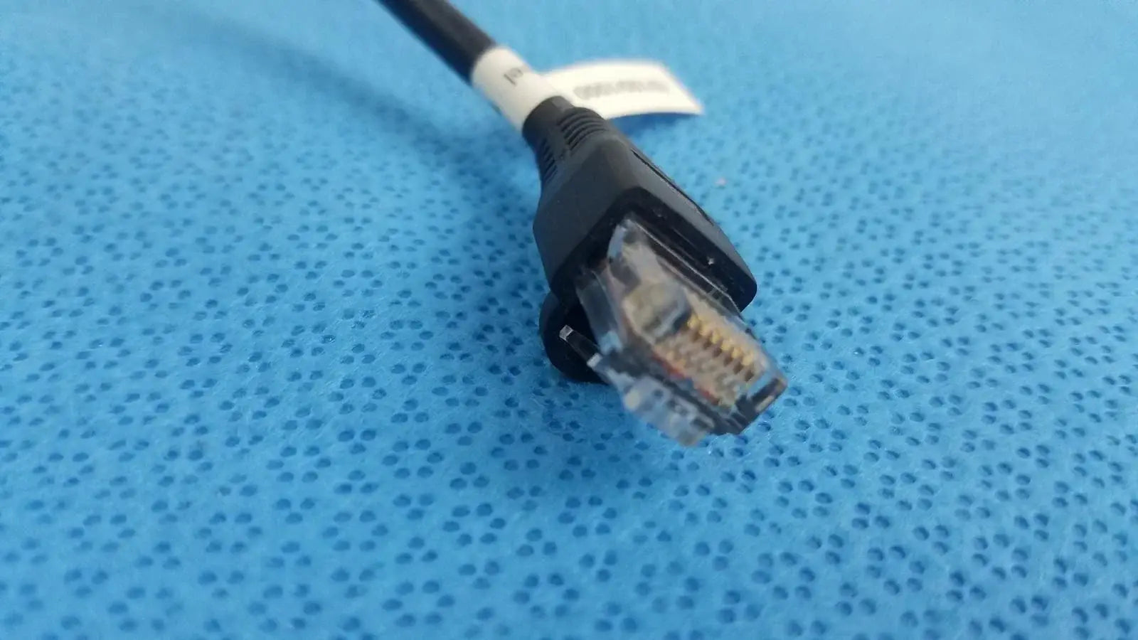 Black retractable cat5e cable with clear rj45 connector and white label for medical equipment and network use
