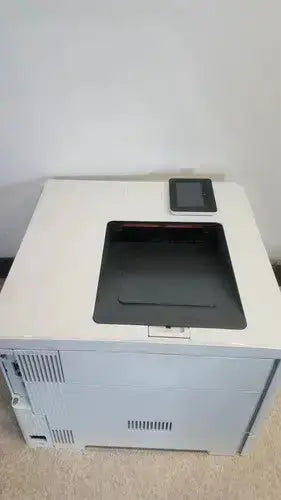 White hp laser printer with black paper tray and touchscreen display in laserjet enterprise m555dn color model