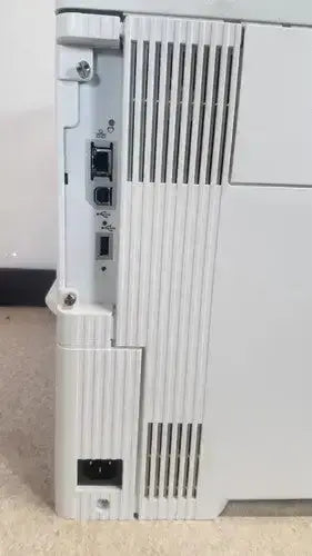 White plastic HP LaserJet Enterprise M555dn laser printer showing side ports and vertical ventilation slats