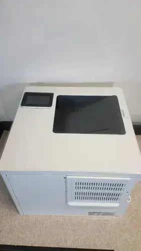 White rectangular HP LaserJet Enterprise M555dn laser printer with black glass tray and small screen on top