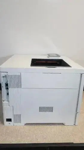 White hp laser printer with sleek rectangular design and side ventilation slits in the laserjet enterprise m555dn color model