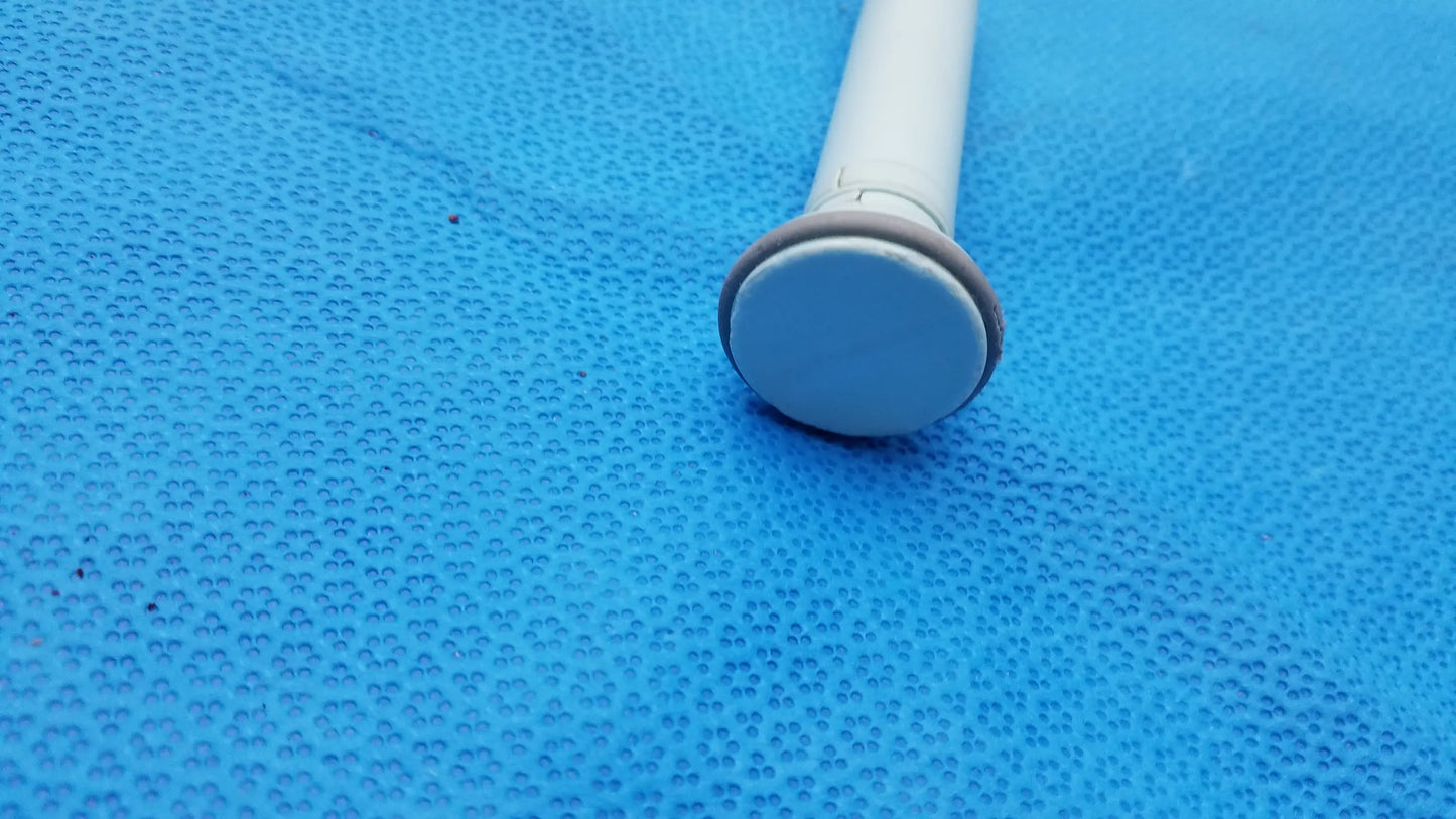 White plastic shower curtain rod with rounded light gray end cap shown alongside huntleigh dopplex d920 handheld doppler medical equipment