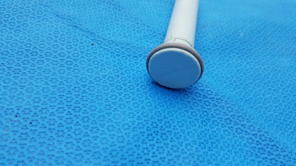 White plastic shower curtain rod with rounded light gray end cap shown alongside huntleigh dopplex d920 handheld doppler medical equipment