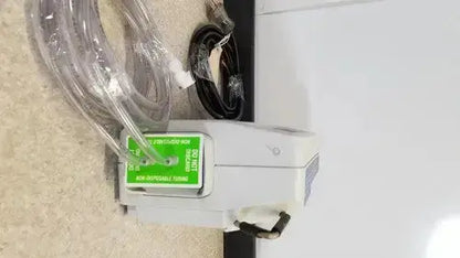 White plastic Huntleigh VP5000 DVT pump with green label and clear tubing for deep vein thrombosis prevention