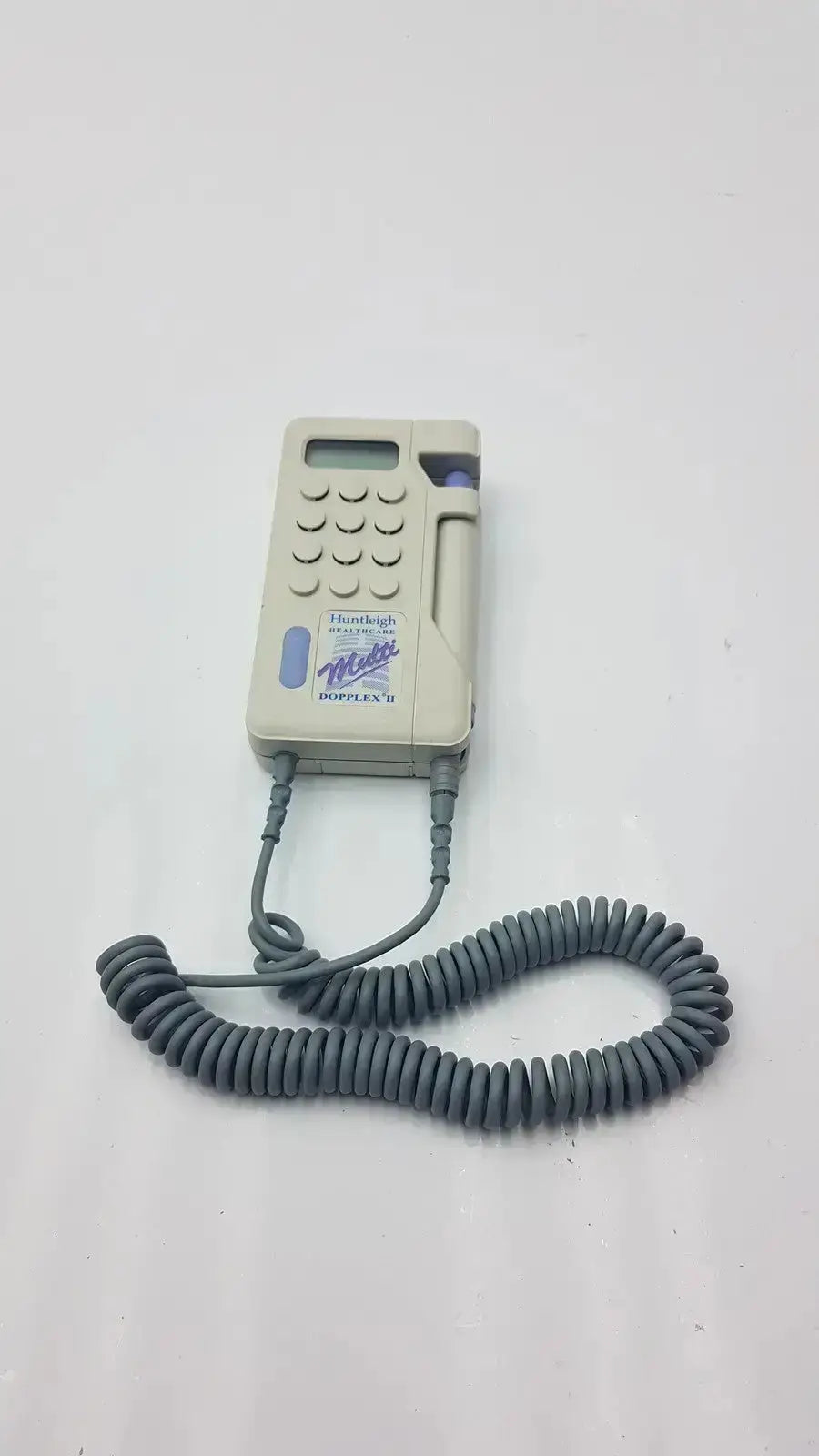 Beige plastic handheld huntleigh dopplex ii md2 medical device with coiled gray cord and purple accents for used medical equipment for sale