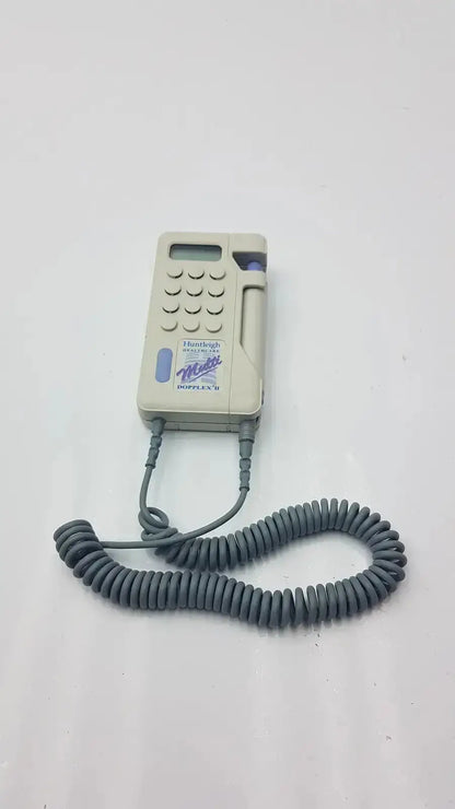 Beige plastic handheld huntleigh dopplex ii md2 medical device with coiled gray cord and purple accents for used medical equipment for sale