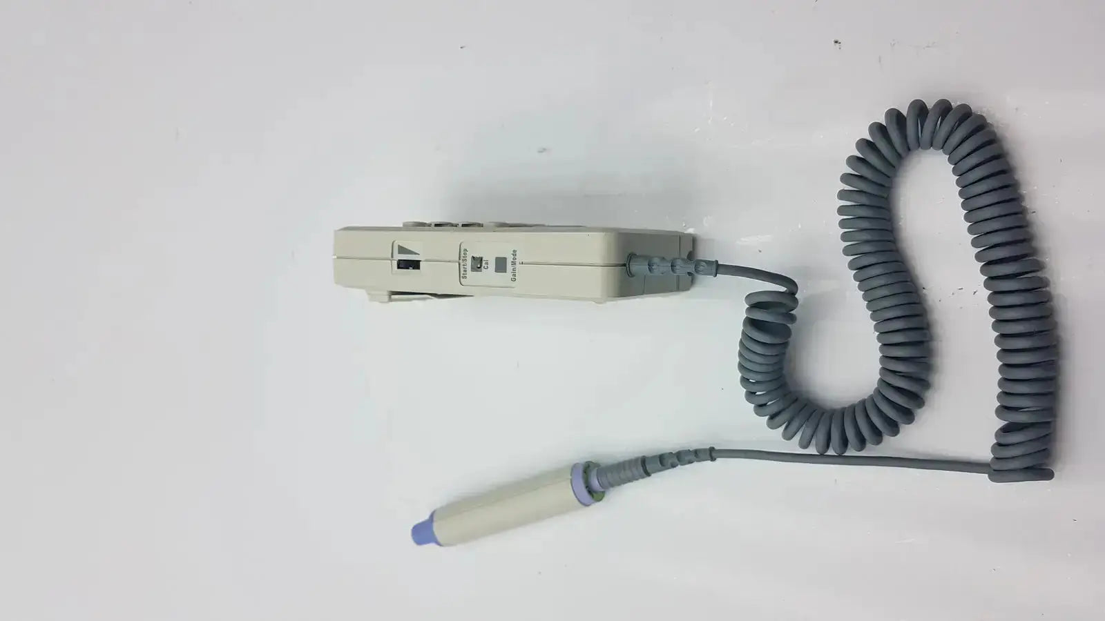 Gray coiled cable connected to a beige huntleigh dopplex ii md2 handheld medical device with a blue-tipped probe for sale