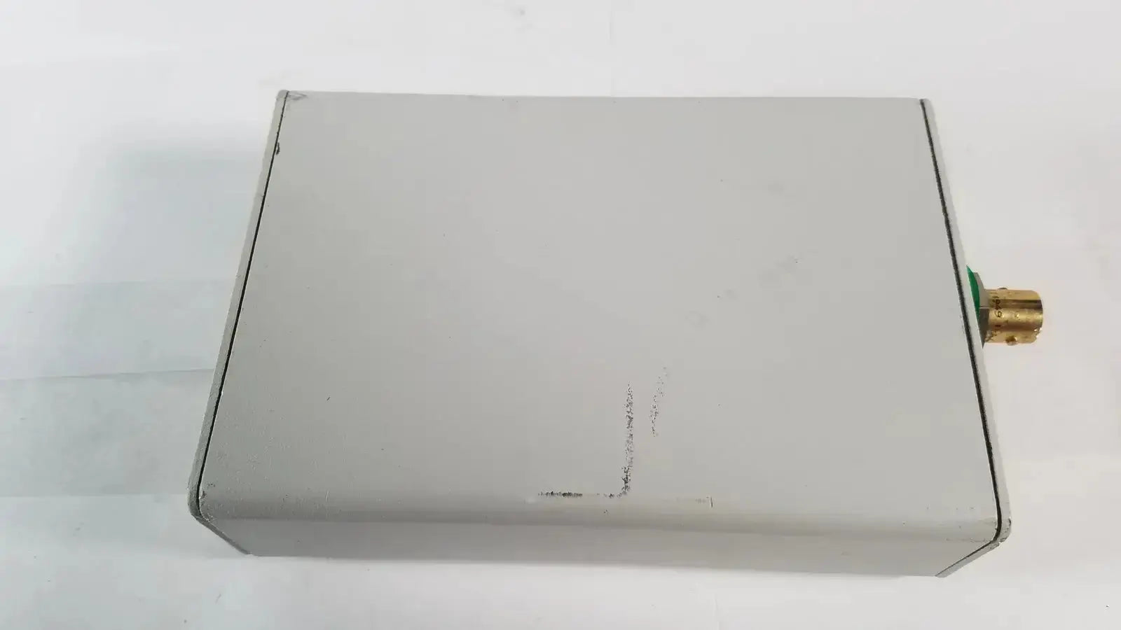 Gray rectangular electronic image stream medical easylink adapter el012277 with brass-colored connector on one side