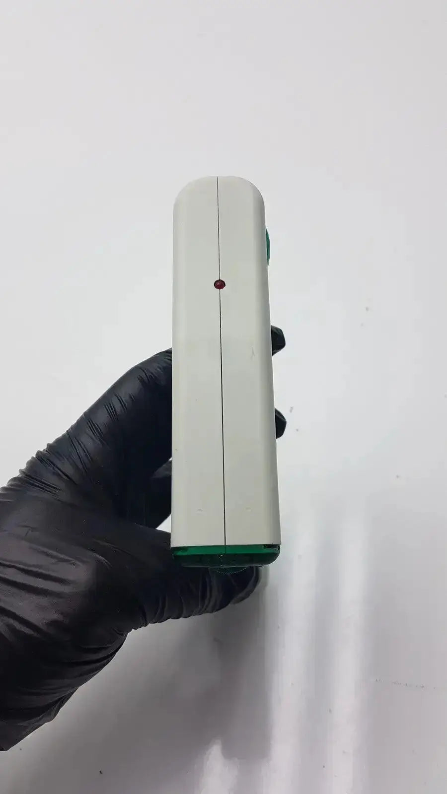 White and green integra biosciences acu pipetboy controller handheld device with a red dot on its side