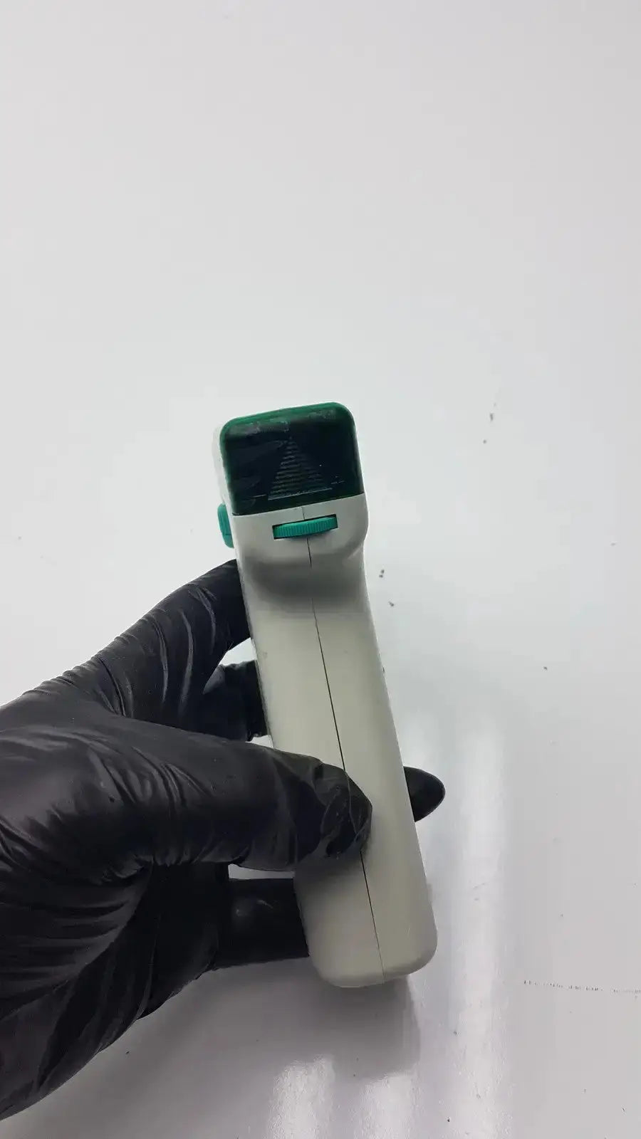 Handheld non-contact infrared thermometer with white body green accents and digital display in integra biosciences acu pipetboy controller