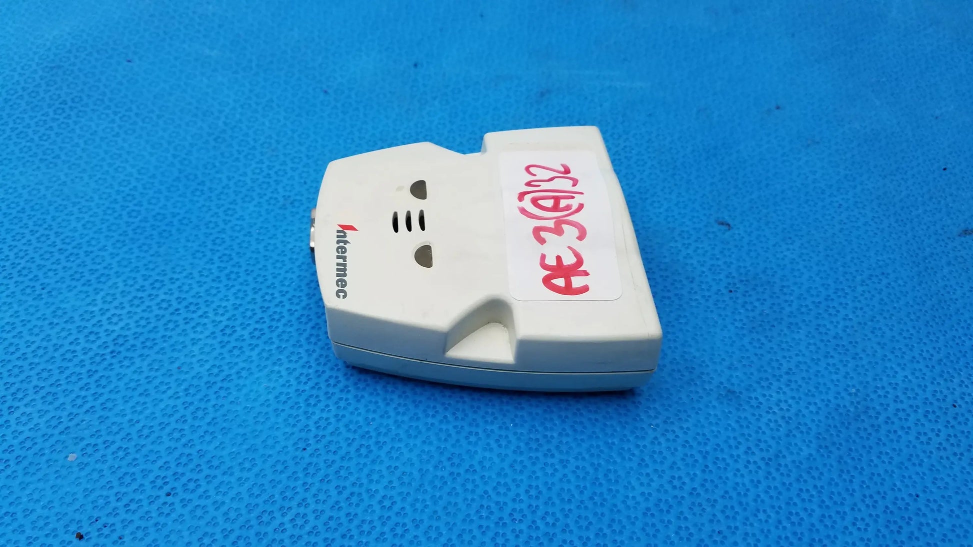 White plastic intermec microbar 9730 decoder wedge with red handwritten label for reuse medical equipment applications