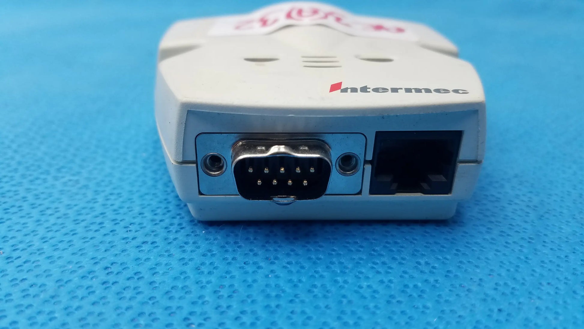White plastic intermec microbar 9730 decoder wedge handheld scanner back view with black db9 serial and ethernet ports for reuse medical equipment