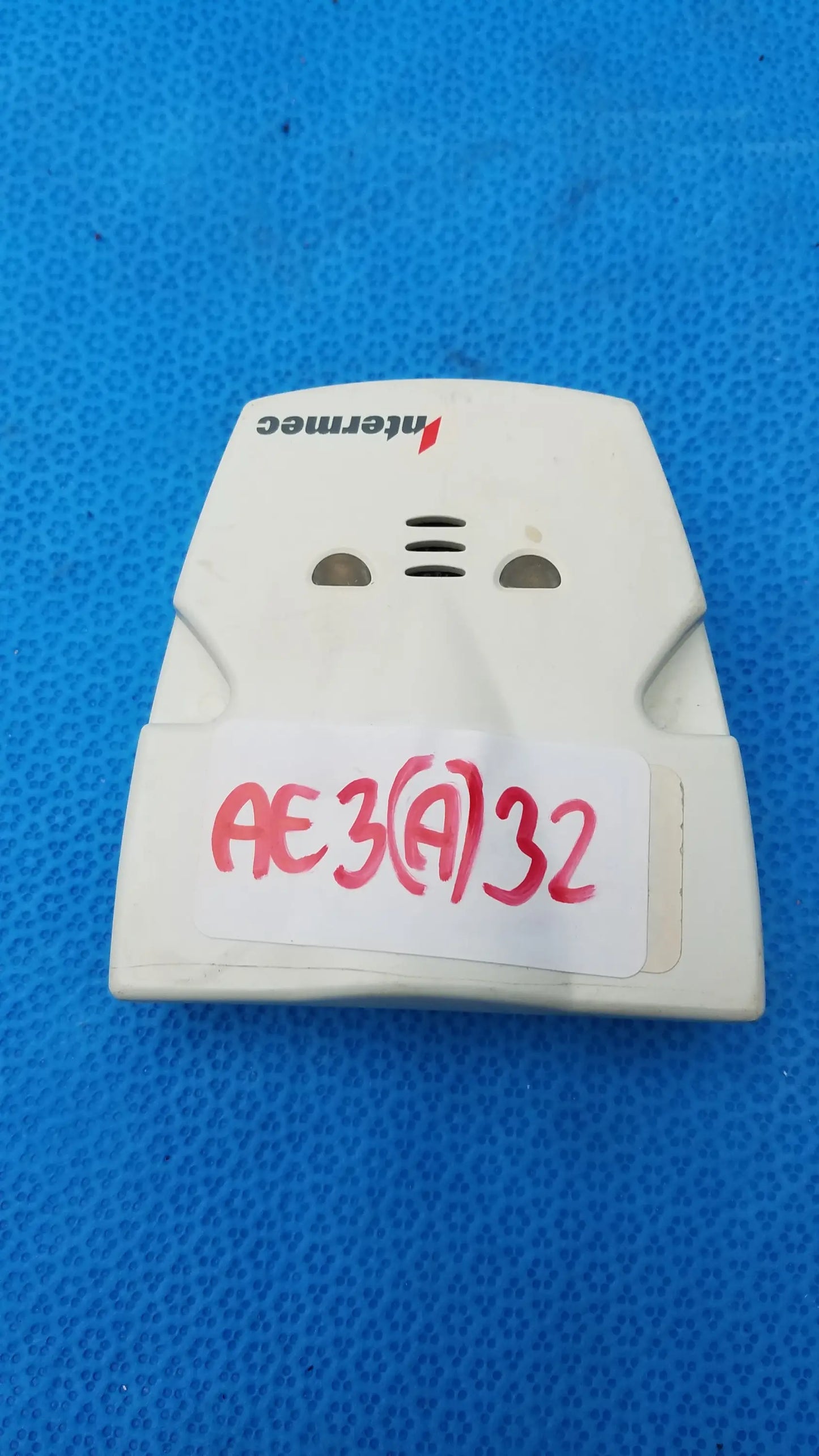 White plastic intermec microbar 9730 decoder wedge smoke detector with vents and handwritten label for reuse medical equipment