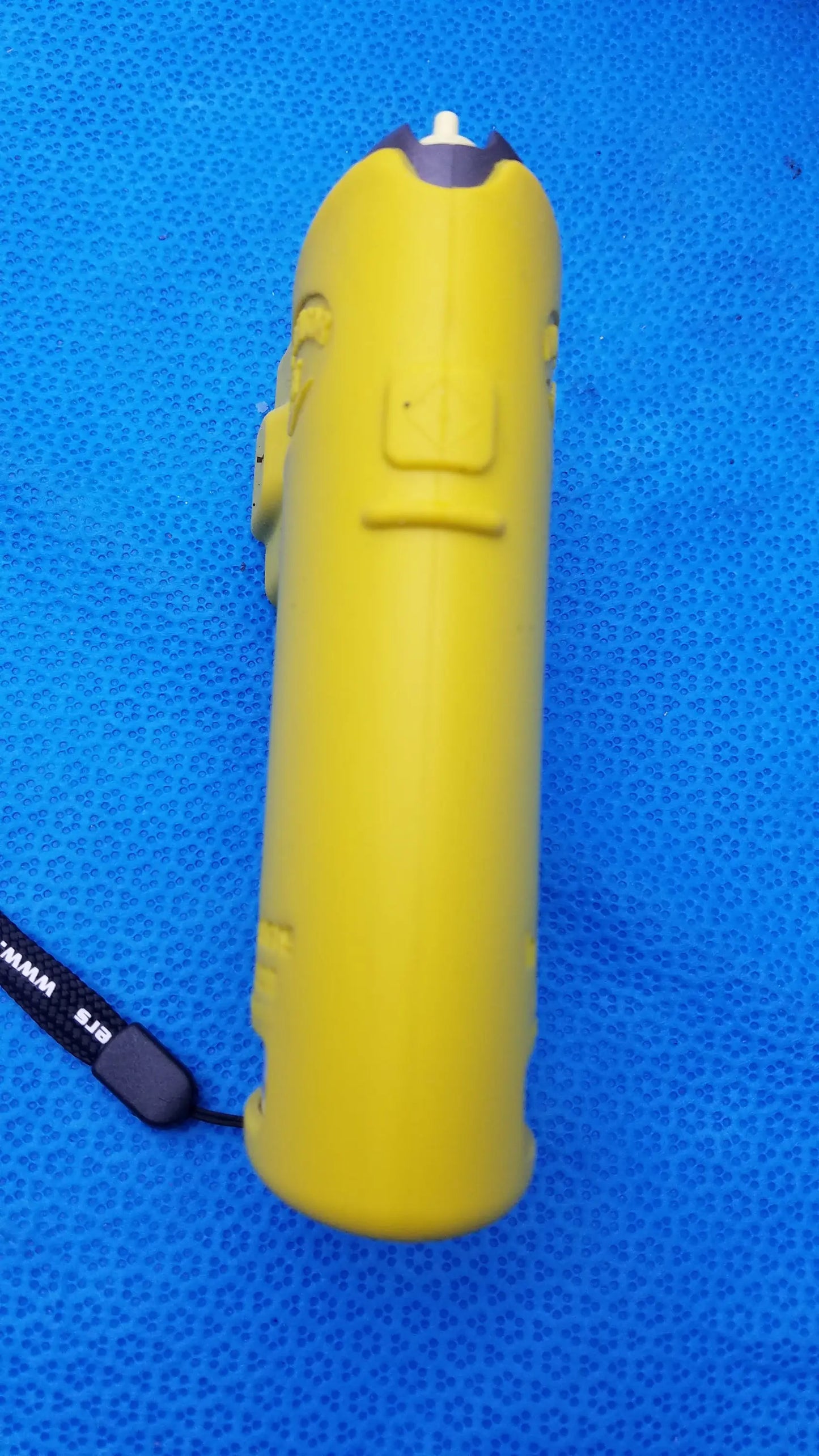 Bright yellow cylindrical stun gun with cartoon face design and black wrist strap shown with intoximeters alco sensor fst case medical equipment