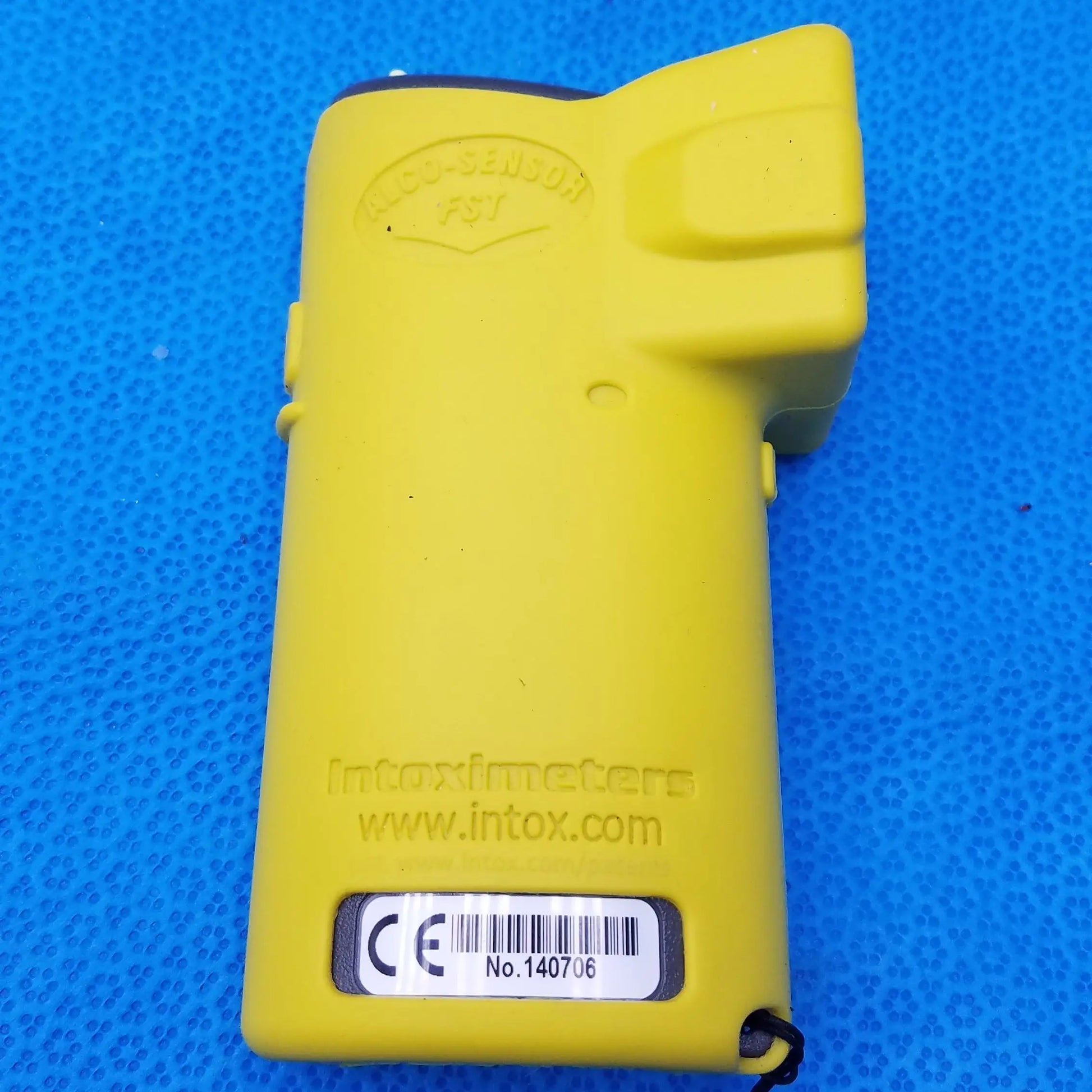 Yellow plastic handheld Intoximeters alco-sensor FST portable breathalyzer with embossed branding and barcode label medical equipment