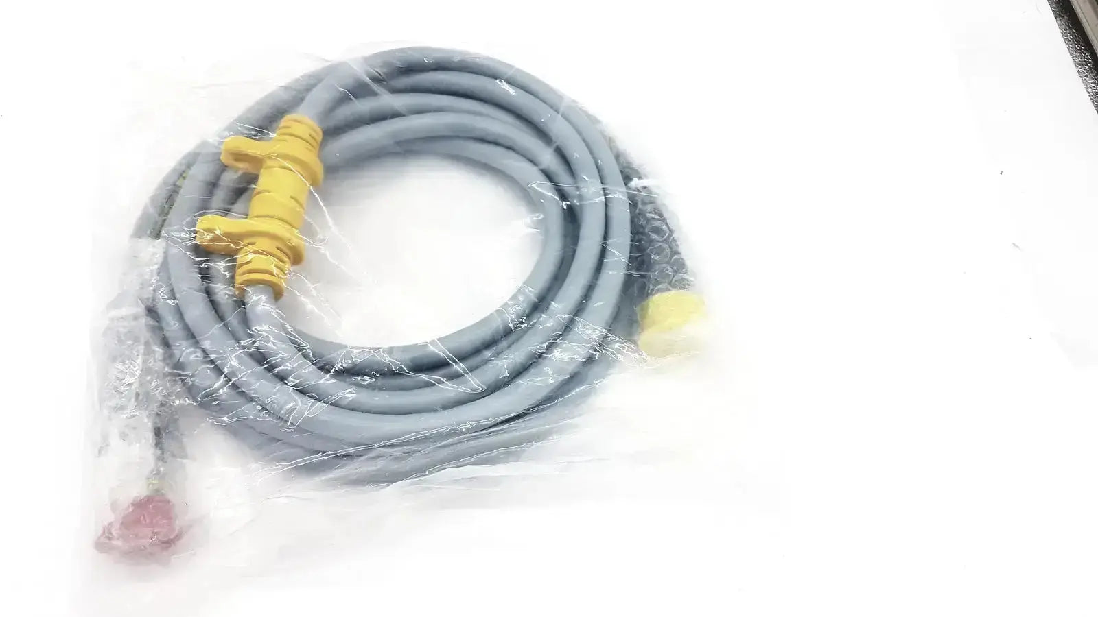 Intuitive Surgical DaVinci gray coiled camera connecting cable with yellow connectors and red plug in clear plastic packaging