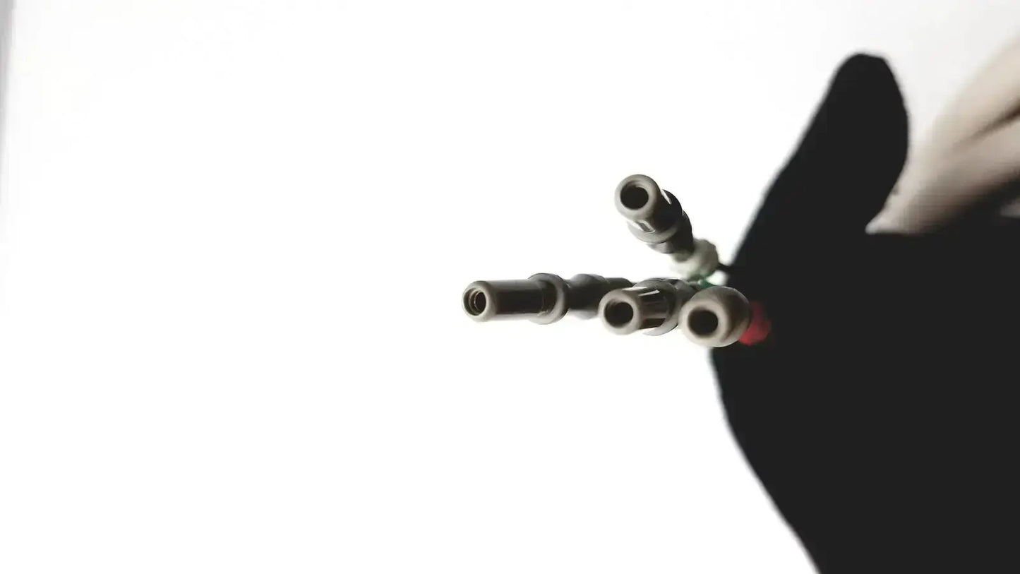 A set of four metallic cylindrical invivo 9240a mri ecg lead wires with threaded ends and a red accent on one connector