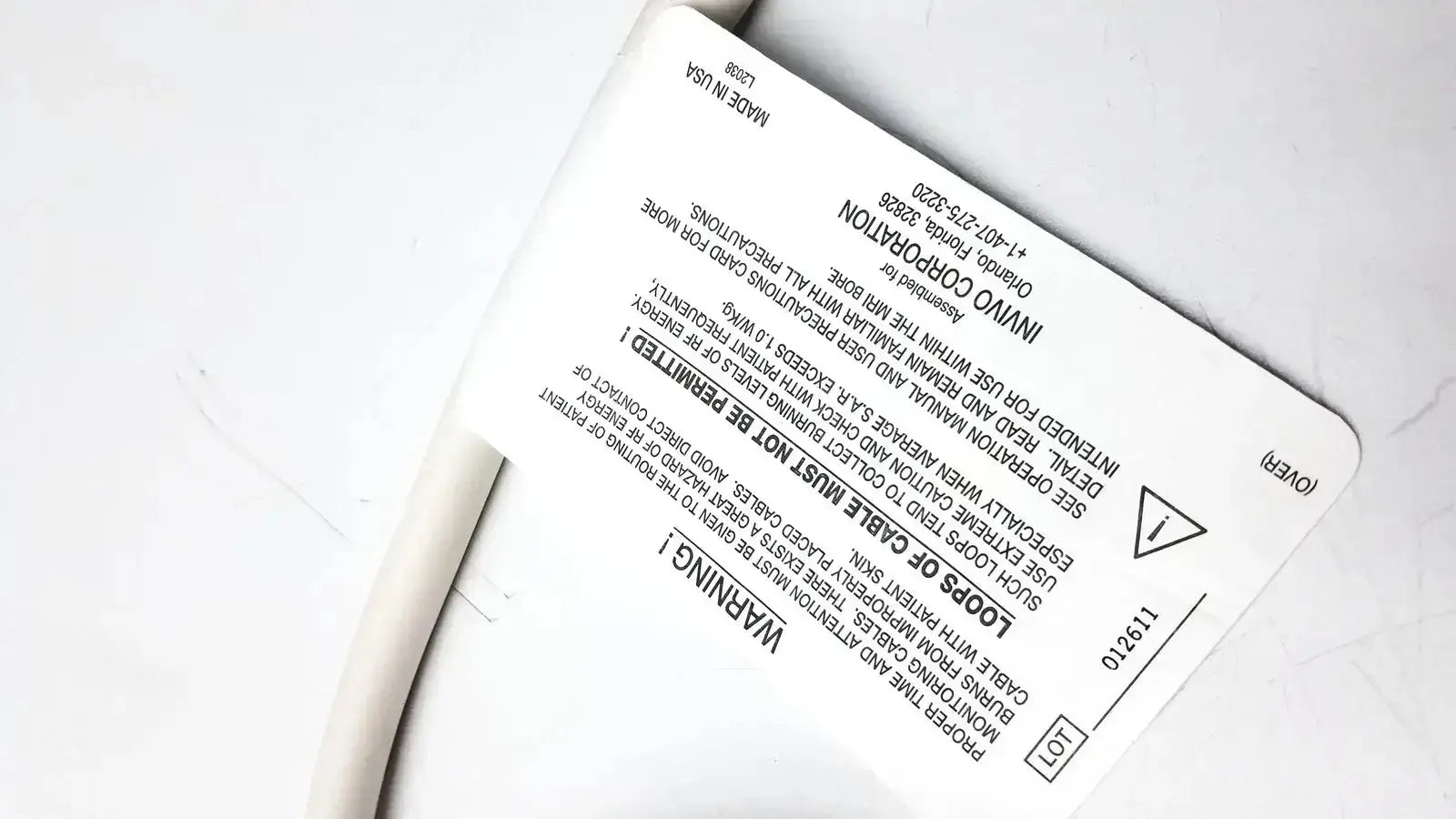 White rectangular label with black text and warning symbol on back of Invivo 9240A MRI ECG lead wires cable