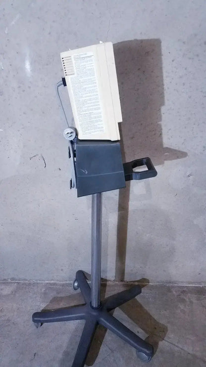 Beige rectangular medical monitor vital check 4200 by ivac corporation vital mounted on black wheeled stand with five-pointed base