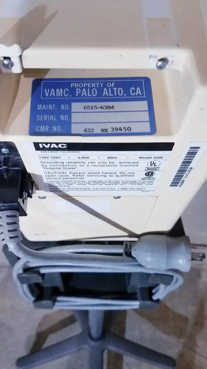Beige ivac corporation vital check 4200 electrical power supply unit with blue label and gray cables on stand