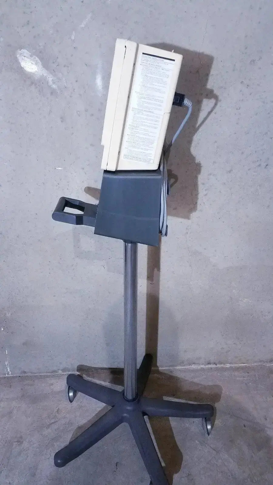 Beige and gray ivac corporation vital check 4200 medical monitor mounted on a wheeled stand for vital check monitoring