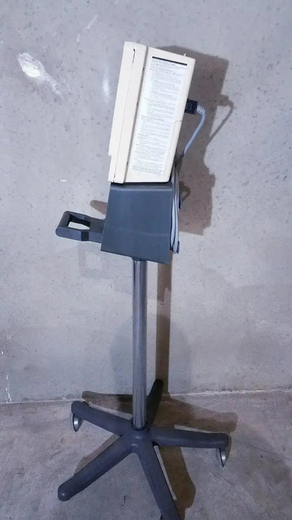 Beige and gray ivac corporation vital check 4200 medical monitor mounted on a wheeled stand for vital check monitoring