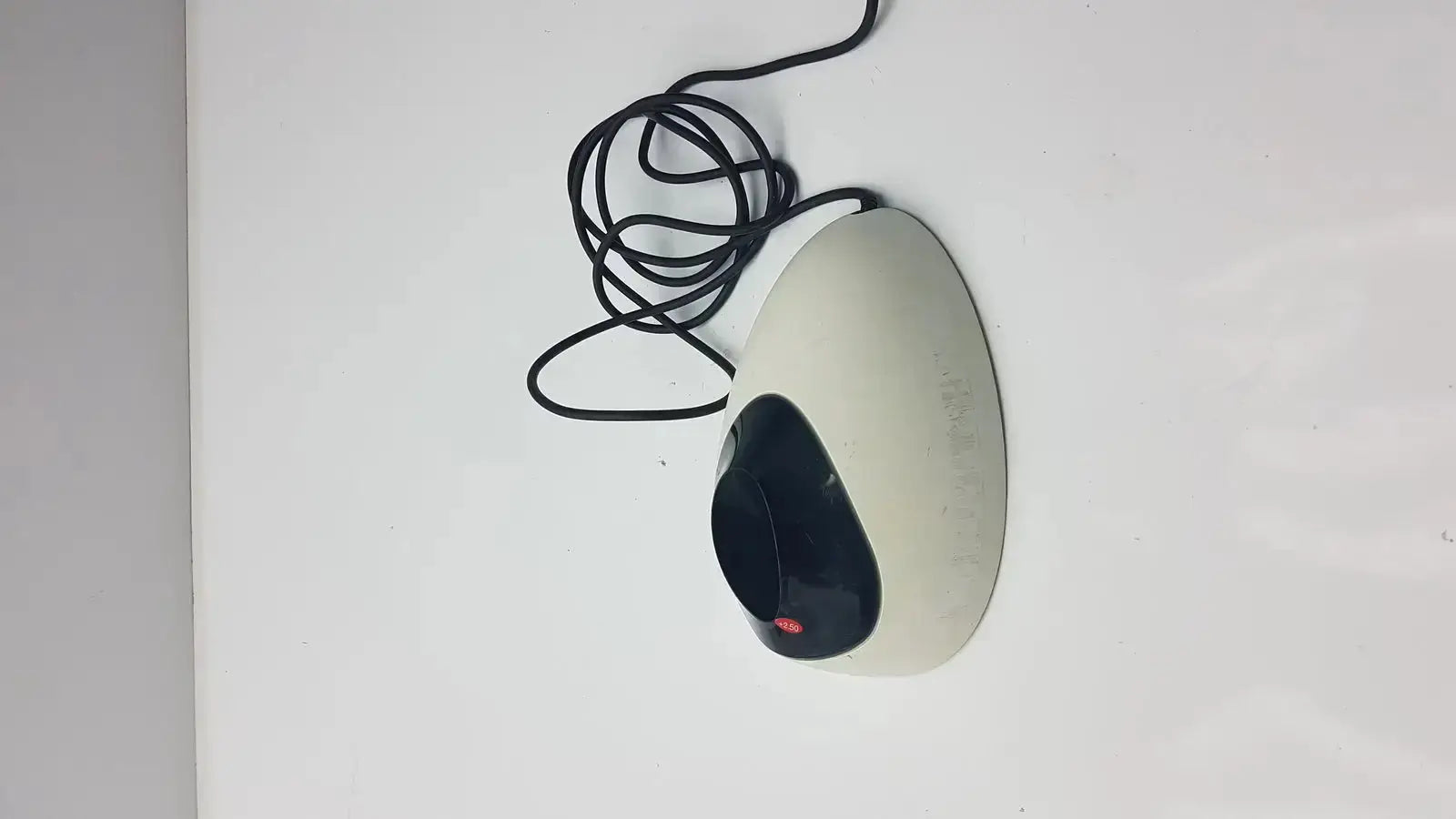 Beige and black ergonomic wired mouse with red logo beside ivoclar vivadent bluephase g2 docking stand
