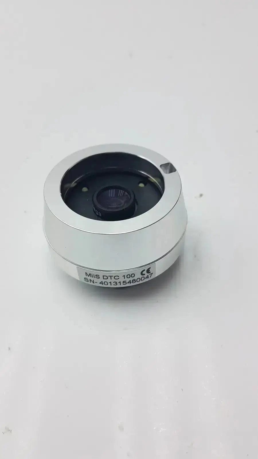 Silver cylindrical jedmed horus dental lens dtc with black central aperture and engraved model details on its side