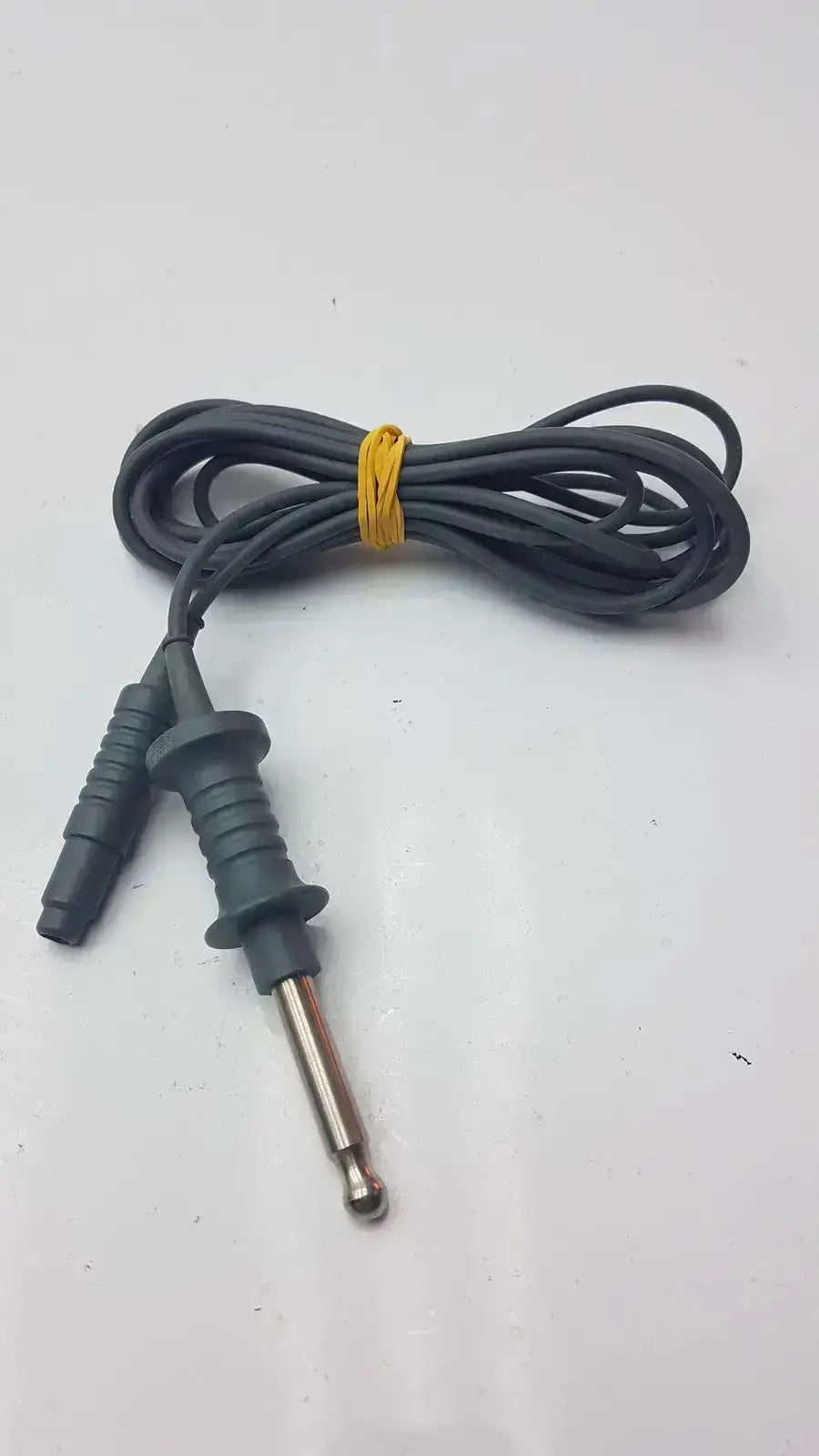 Black coiled karl storz 26006 m high-frequency unipolar cord with metallic tip and black plastic connector housing