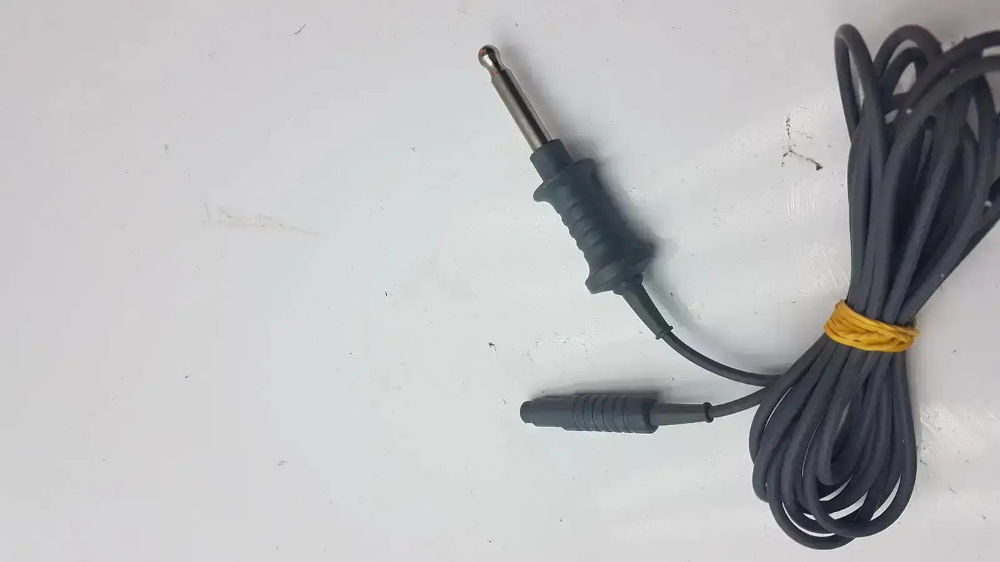 Black coiled karl storz 26006 m high-frequency unipolar cord with metallic 6.35mm audio jack and rubberized grip secured by yellow tie