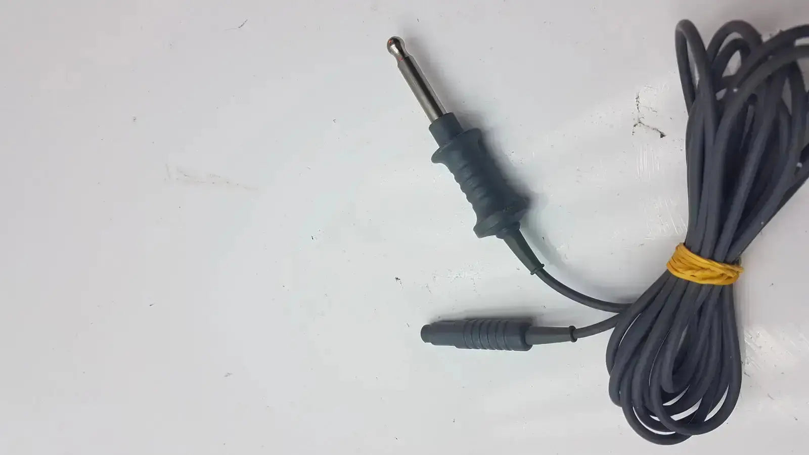 Black coiled karl storz 26006 m high-frequency unipolar cord with metallic 6.35mm audio jack and rubberized grip secured by yellow tie