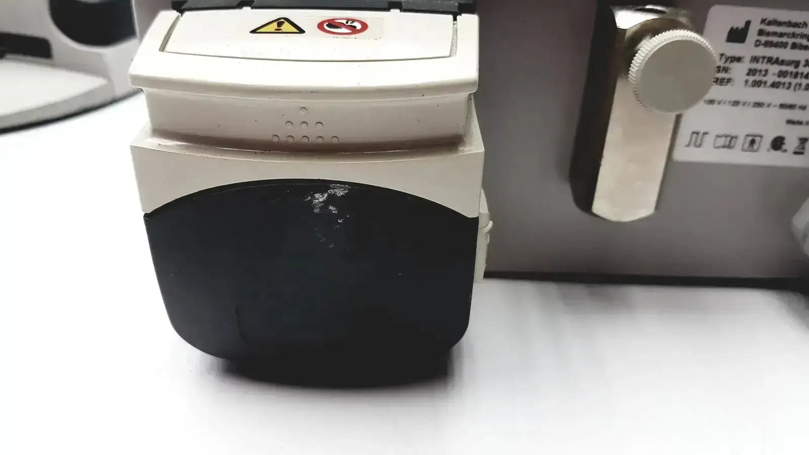 White and black kavo intrasurg 300 dental implant drill system with warning labels for surgical dental implant use