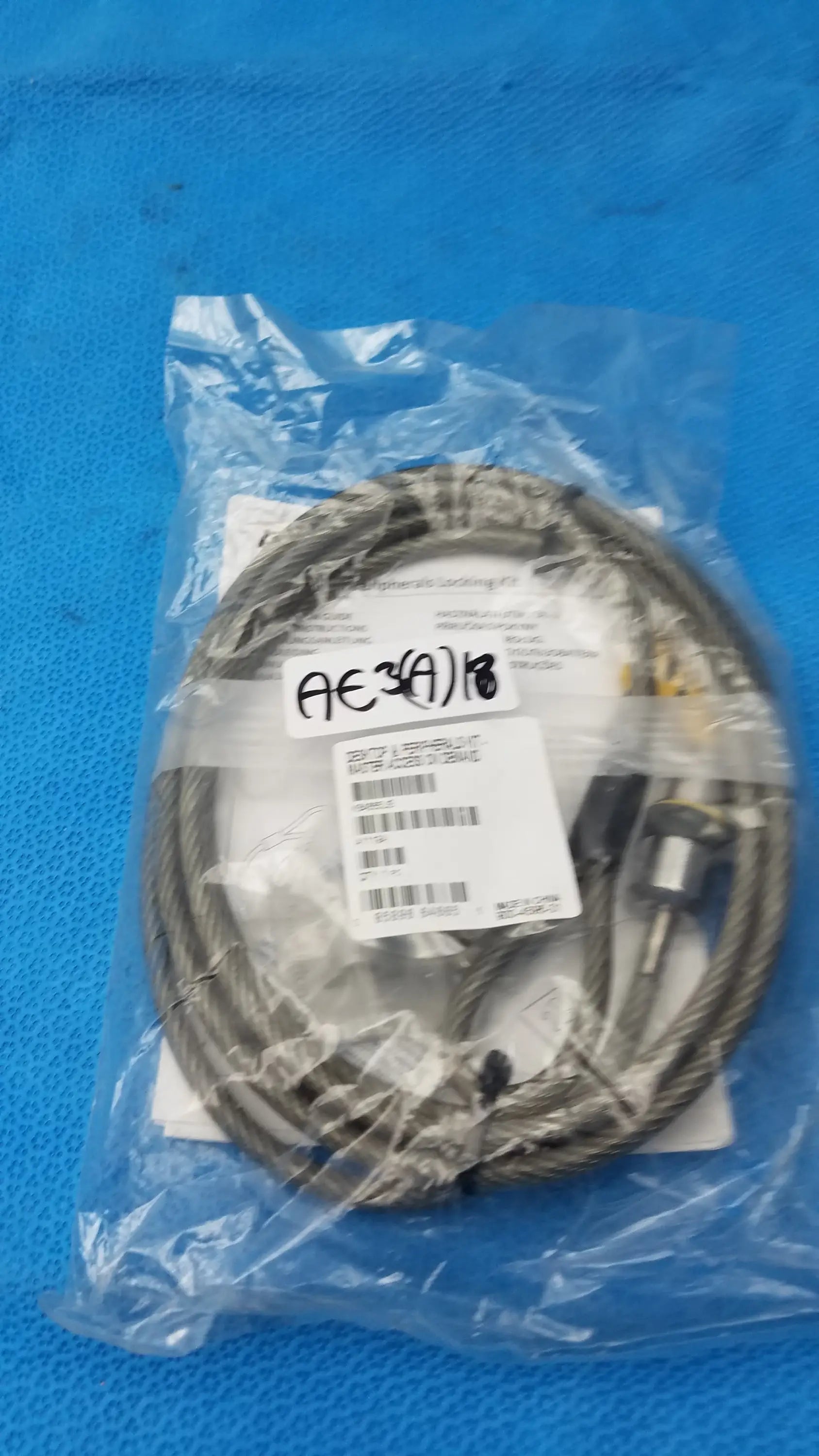 Coiled metallic gray steel cable with braided texture and black connectors in kensington k64665us locking kit for pre owned medical equipment