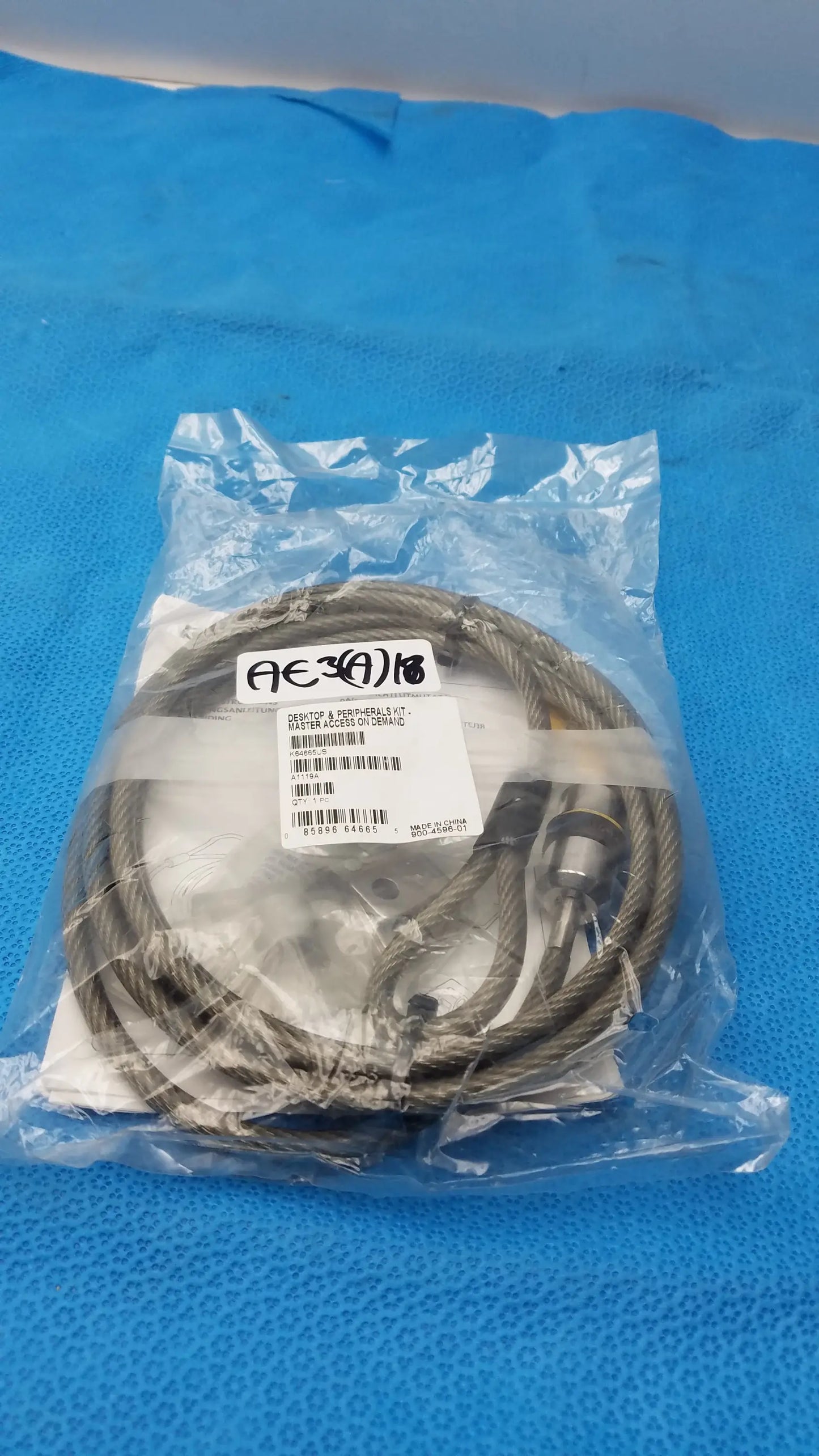 A coiled gray steel cable with metallic connector packaged in clear plastic from kensington k64665us locking kit for used medical equipment sale