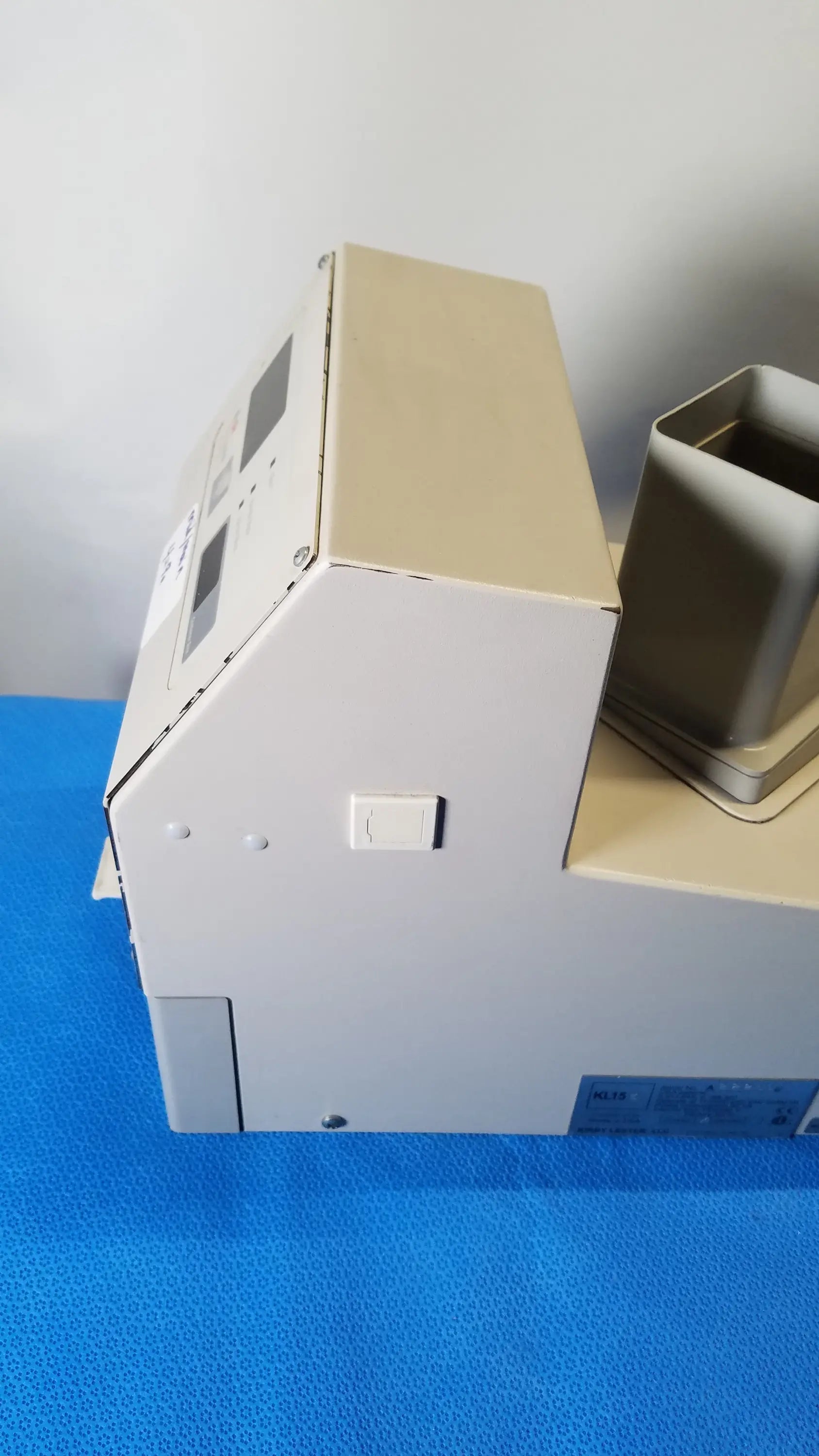 Beige and white kirby lester kl15e pharmacy tablet counter with rectangular control panel and metallic components medical equipment
