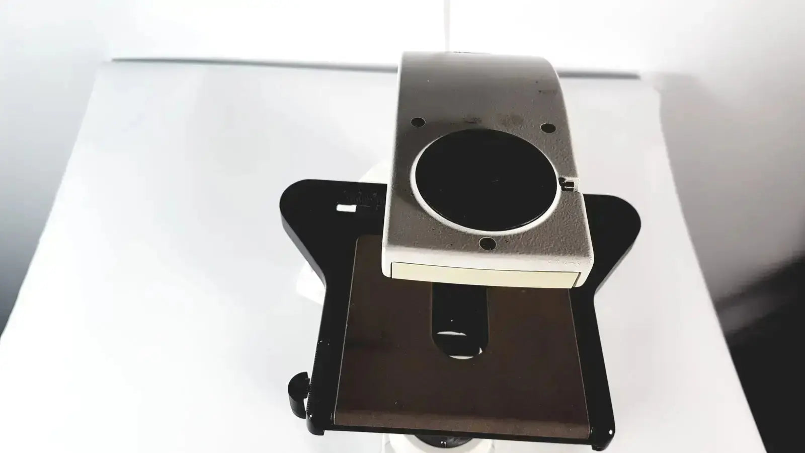 Silver and black digital camera mount with circular lens opening for leica dm1000 led microscope microsystems base