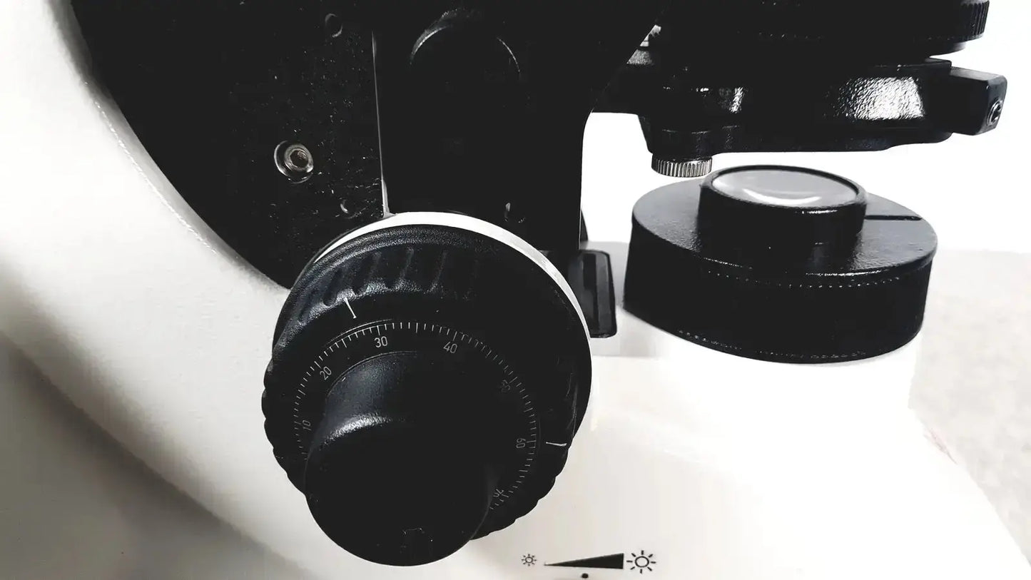 Black textured knob with circular degree scale on white surface of leica dm1000 pre owned medical equipment for sale