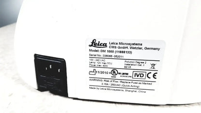 White leica dm1000 microscope base with black power plug and specifications label showing used medical equipment for sale