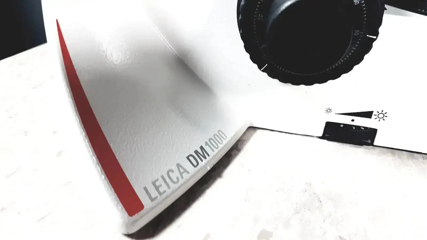 Leica dm1000 microscope with white and red body and black rotary dial pre owned medical equipment for sale