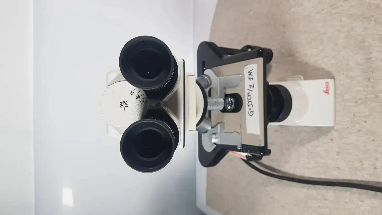 Leica dm1000 binocular microscope with black eyepieces and white body for pre owned medical equipment sale