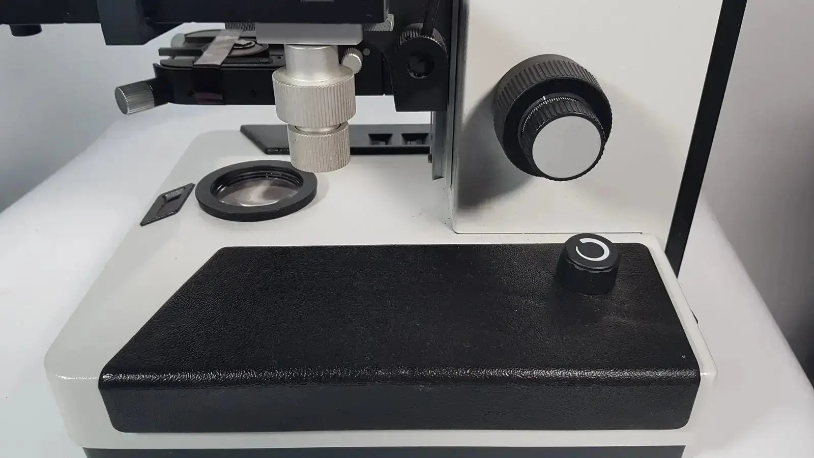 Black and silver Leitz Metallux 3 stereo zoom microscope with adjustable focus knob and stage clamp for precision viewing