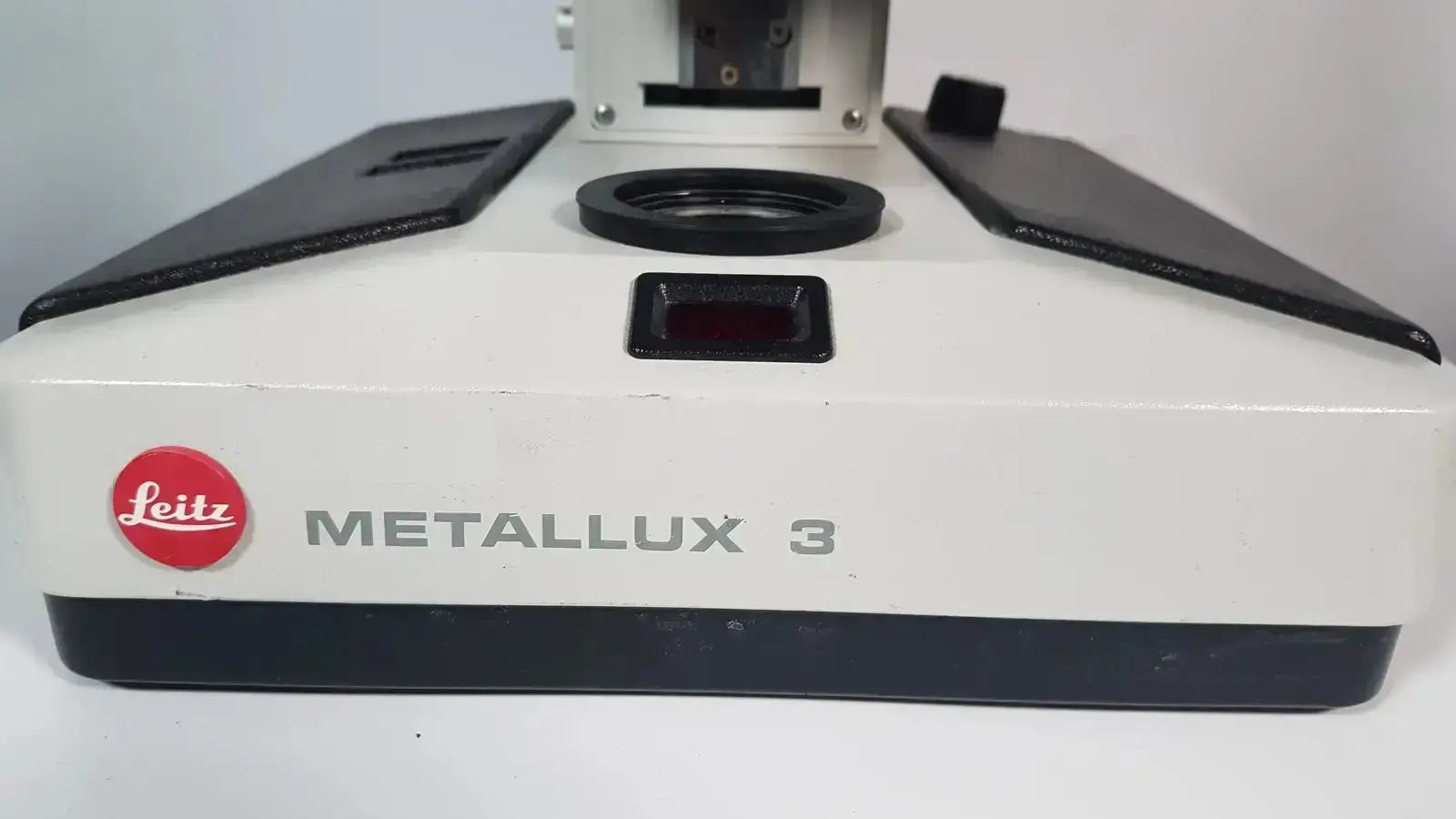 White and black leitz metallux 3 stereo zoom microscope with red logo on front for precise magnification tasks