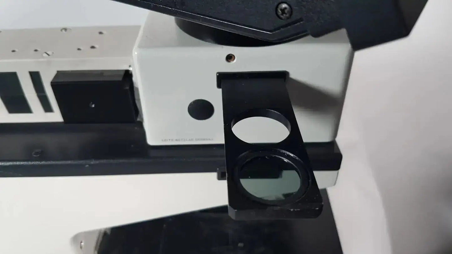 Black circular lens holder with clear glass lens attached to white and black base of leitz metallux 3 stereo zoom microscope