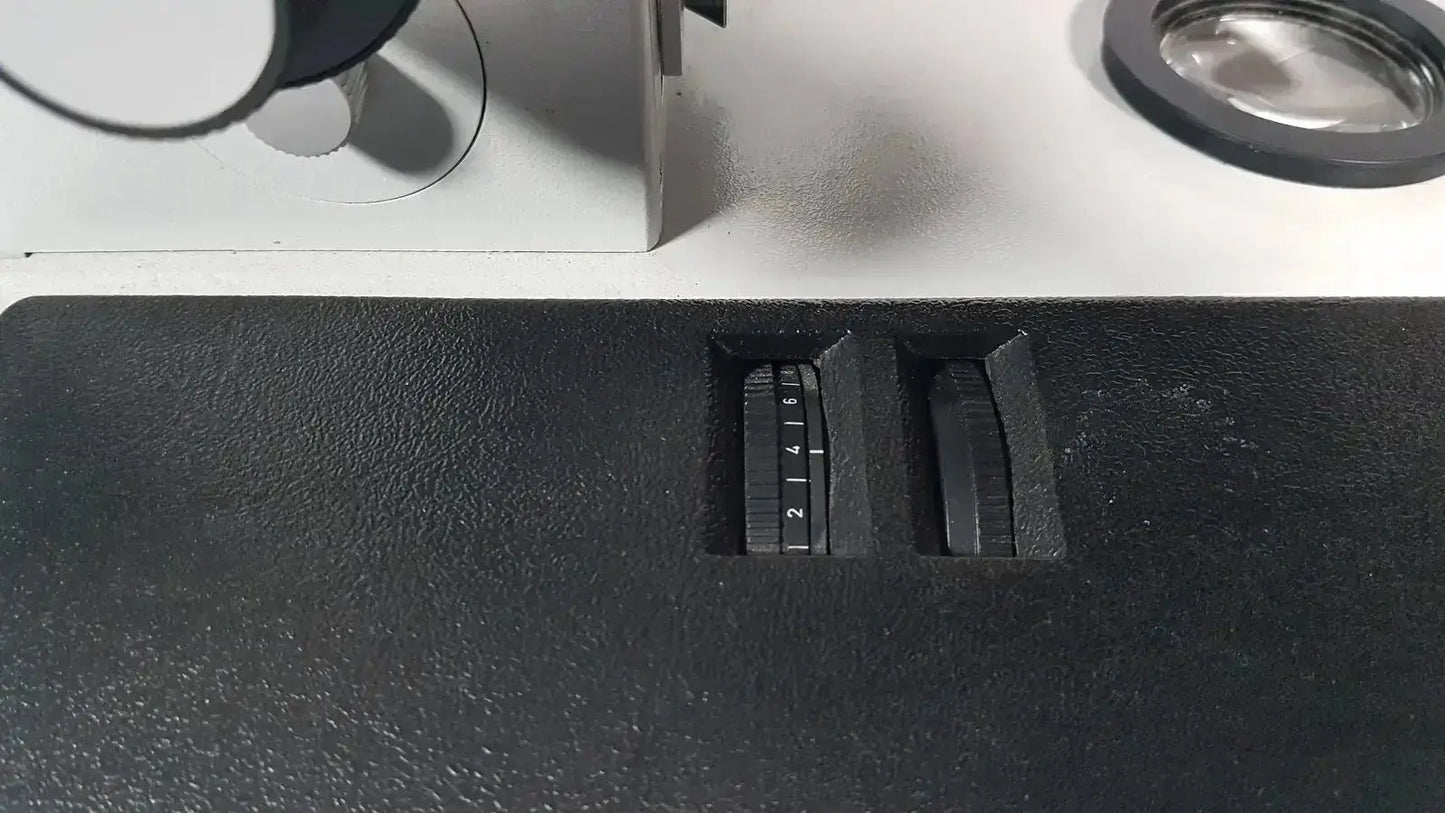 Black textured surface with two numbered dials on leitz metallux 3 stereo zoom microscope for precise magnification control