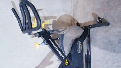 Black and yellow Lemond Fitness RevMaster sport cycling bike with sleek modern design for indoor exercise