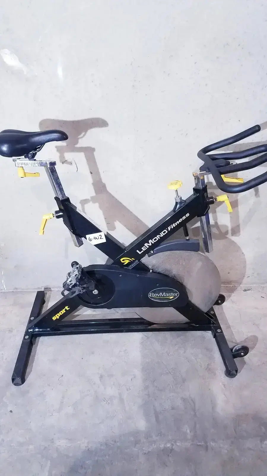 Black LeMond Fitness RevMaster sport cycling bike with yellow accents and gray flywheel model 15700-3