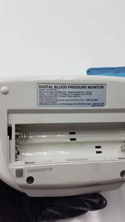White plastic life source ua-767 plus digital blood pressure monitor showing model label and battery compartment